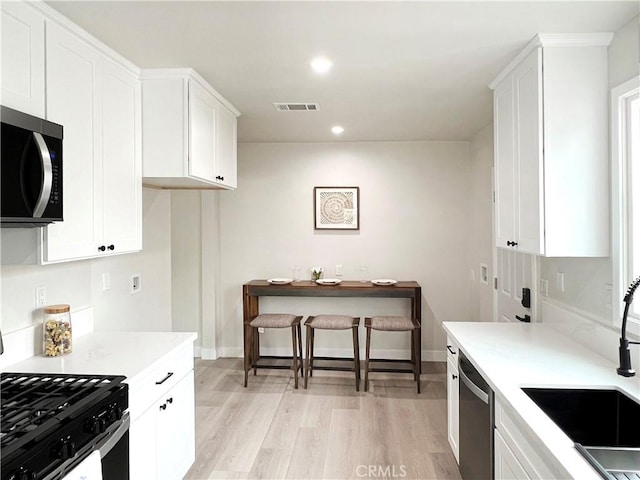 834 Morada Pl, Altadena, CA 91001 - kitchen with stainless steel appliances, visible vents, a sink, light wood-style flooring, and white cabinetry