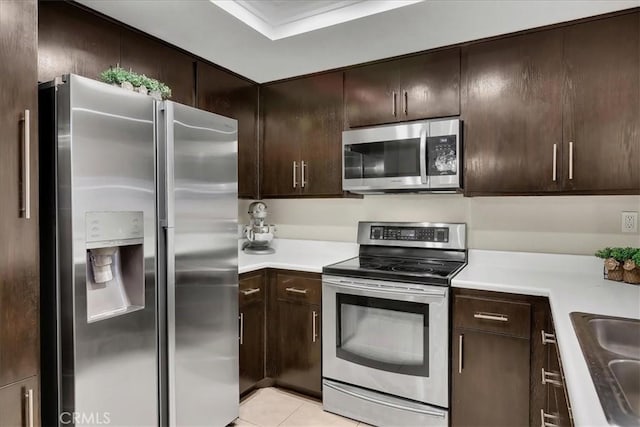 2800 Keller Dr Unit 285, Tustin, CA 92782 - kitchen with light countertops, dark brown cabinetry, stainless steel appliances, and light tile patterned floors
