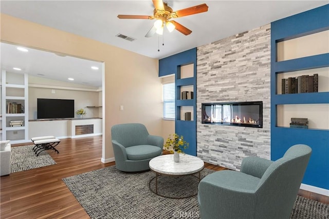 44863 Rein Ct, Temecula, CA 92592 - living room featuring wood finished floors, a multi sided fireplace, built in shelves, and ceiling fan