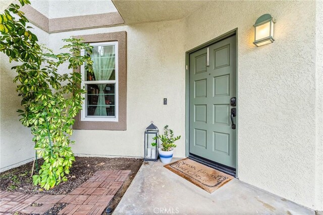 view of exterior entry featuring stucco siding
