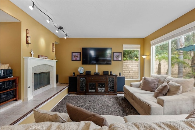tiled living room featuring a tiled fireplace and rail lighting