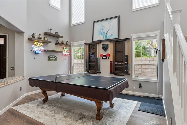 game room featuring wood finished floors, billiards, baseboards, and a high ceiling