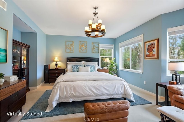 bedroom with multiple windows, a notable chandelier, light carpet, and visible vents