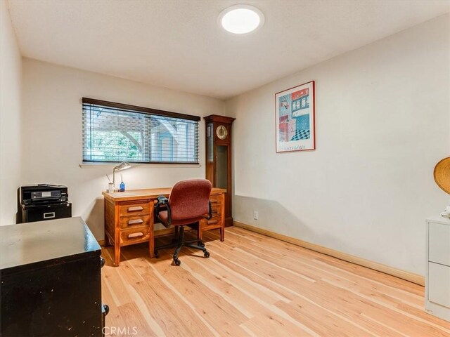 office space with light wood-style floors and baseboards