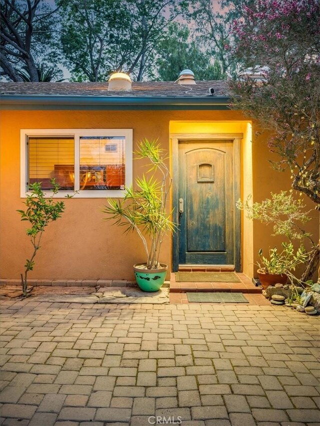view of exterior entry featuring stucco siding