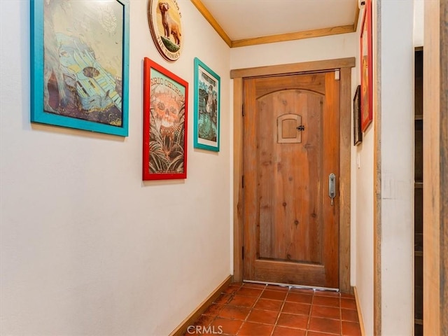 doorway to outside featuring tile patterned flooring, baseboards, and ornamental molding