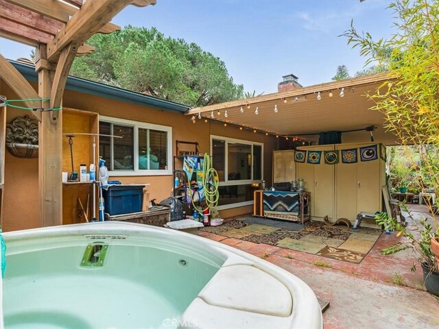 rear view of property featuring a patio and a chimney