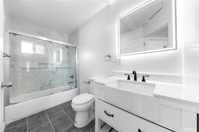 bathroom with combined bath / shower with glass door, vanity, and toilet