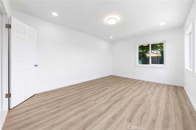 empty room with baseboards, recessed lighting, and light wood-style floors