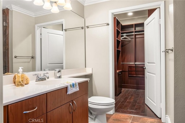 bathroom featuring ornamental molding, vanity, and toilet