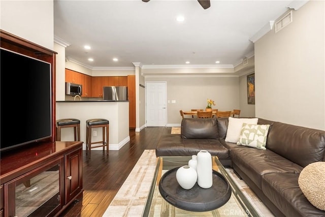 living area with dark wood-type flooring, crown molding, recessed lighting, and baseboards