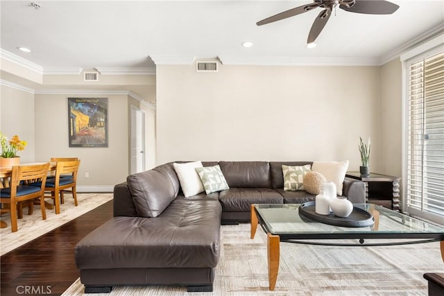 living area with ornamental molding, ceiling fan, baseboards, recessed lighting, and wood finished floors
