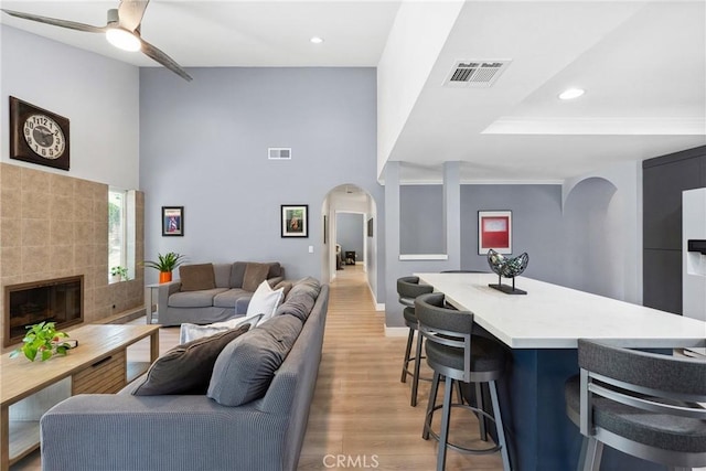 7701 Quimby Ave, West Hills, CA 91304 - living room with arched walkways, light wood-style floors, recessed lighting, a towering ceiling, and ceiling fan