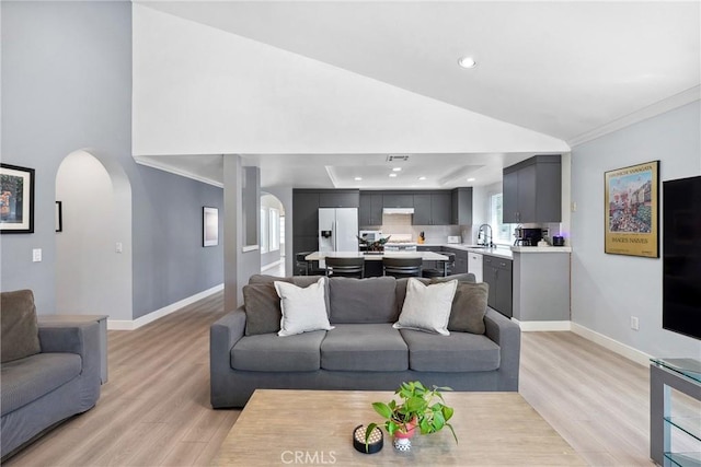 7701 Quimby Ave, West Hills, CA 91304 - living room featuring arched walkways, light wood-style floors, recessed lighting, crown molding, and lofted ceiling