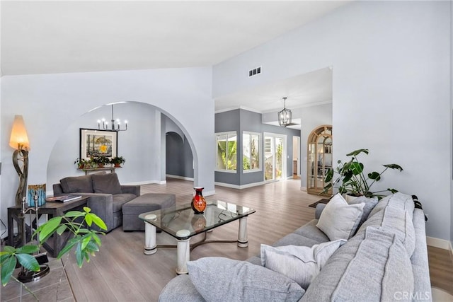 7701 Quimby Ave, West Hills, CA 91304 - living area featuring a chandelier, arched walkways, wood finished floors, lofted ceiling, and ornamental molding