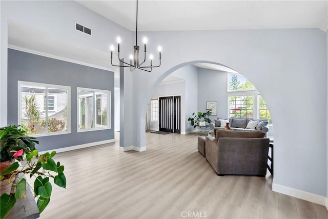 7701 Quimby Ave, West Hills, CA 91304 - living room with healthy amount of natural light, light wood-style flooring, arched walkways, and a chandelier