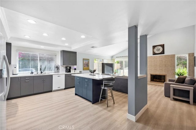 7701 Quimby Ave, West Hills, CA 91304 - kitchen featuring open floor plan, dishwasher, a center island, a kitchen bar, and light wood-style floors