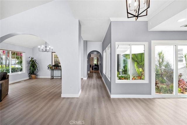 7701 Quimby Ave, West Hills, CA 91304 - foyer featuring a chandelier, arched walkways, wood finished floors, and ornamental molding