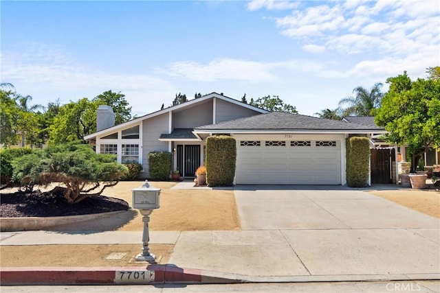 7701 Quimby Ave, West Hills, CA 91304 - mid-century modern home featuring an attached garage, driveway, and a chimney
