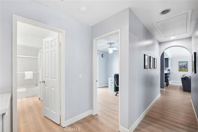7701 Quimby Ave, West Hills, CA 91304 - hall featuring light wood-style flooring, attic access, and arched walkways