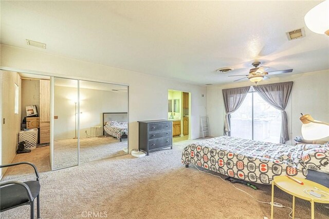 bedroom featuring visible vents, a closet, ceiling fan, ensuite bath, and carpet floors