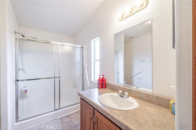bathroom with a shower stall, vanity, and tile patterned flooring