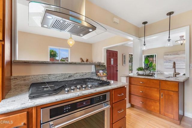 4806 Glenwood Ave, La Crescenta, CA 91214 - kitchen with appliances with stainless steel finishes, a sink, brown cabinets, ventilation hood, and decorative light fixtures