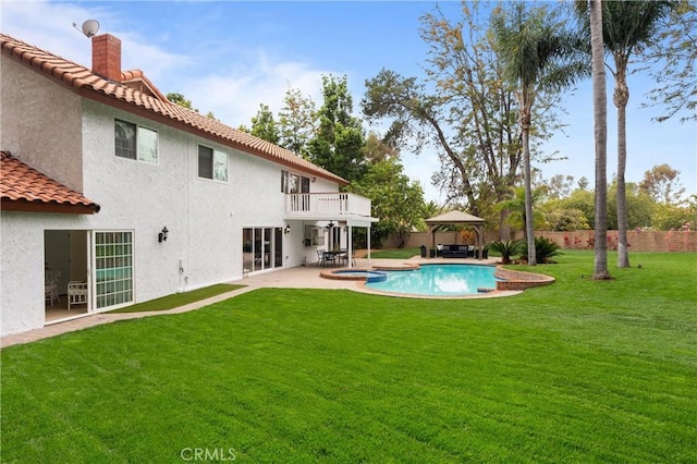 rear view of house with a gazebo, fence, a patio area, a balcony, and a yard