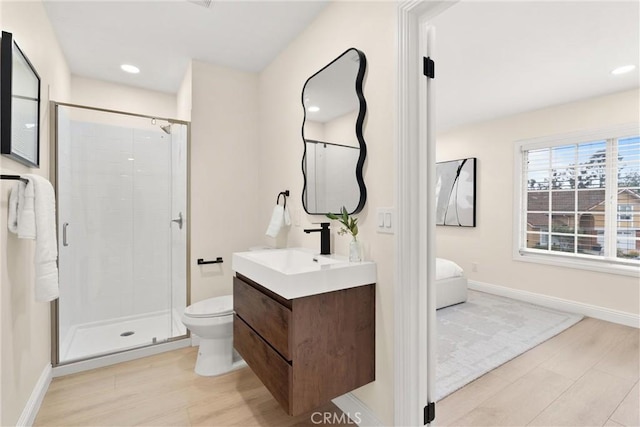 full bathroom featuring a shower stall, baseboards, toilet, and wood finished floors