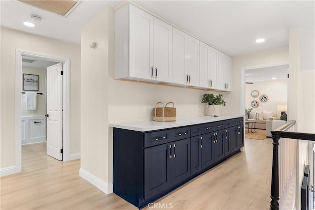 hallway with light wood-type flooring, baseboards, and recessed lighting