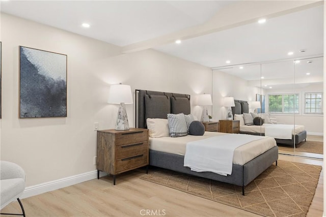 bedroom with baseboards, wood finished floors, and recessed lighting