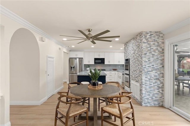 dining room featuring light wood-style flooring, arched walkways, recessed lighting, ceiling fan, and ornamental molding