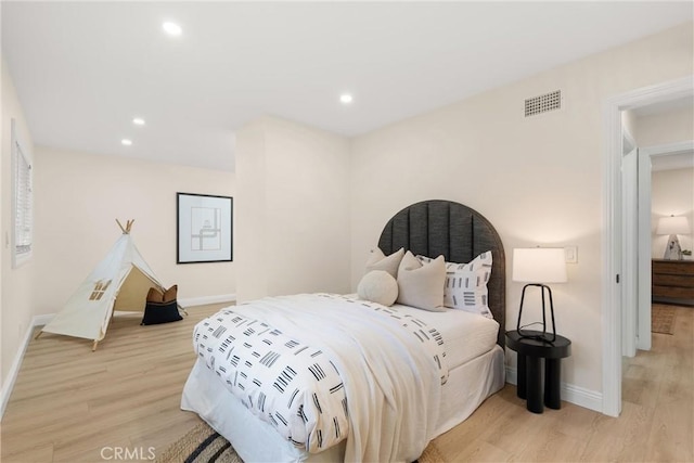 bedroom with baseboards, light wood-style floors, visible vents, and recessed lighting
