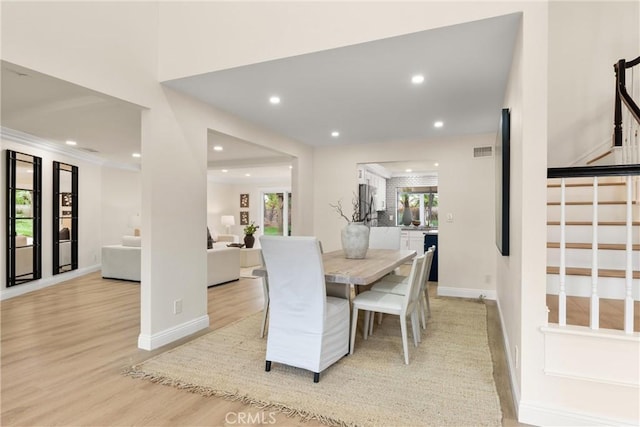 dining room with light wood-type flooring, visible vents, recessed lighting, and stairs