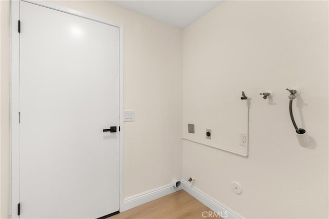 laundry room featuring laundry area, hookup for an electric dryer, light wood-style floors, hookup for a gas dryer, and baseboards