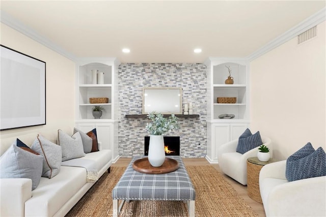 living area with a tile fireplace, visible vents, wood finished floors, and built in features