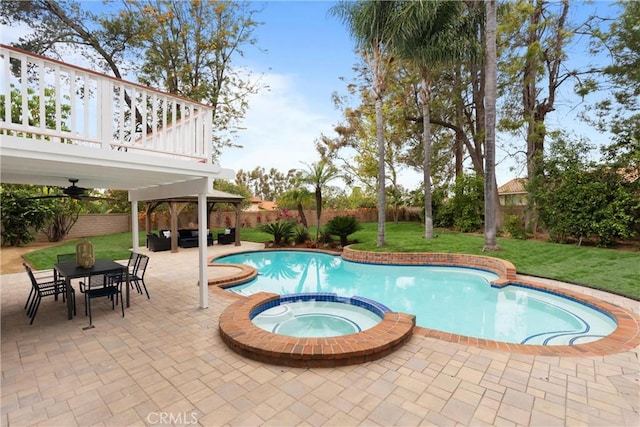 view of swimming pool featuring a yard, a pool with connected hot tub, a fenced backyard, and an outdoor living space