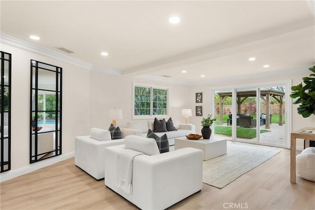 living room with recessed lighting, ornamental molding, a healthy amount of sunlight, and light wood finished floors