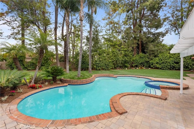 view of pool with a lawn and a pool with connected hot tub