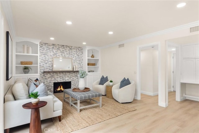 living area with light wood finished floors, baseboards, recessed lighting, built in shelves, and a fireplace