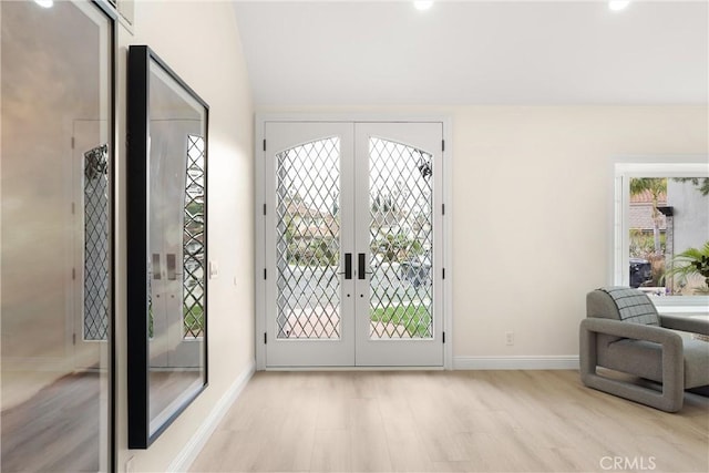 doorway featuring wood finished floors, baseboards, and french doors