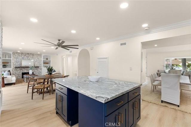kitchen featuring arched walkways, light wood-type flooring, open floor plan, recessed lighting, and a ceiling fan