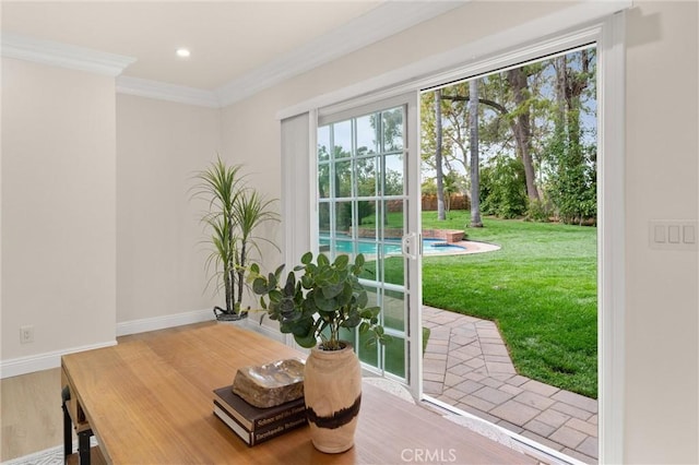 interior space with ornamental molding, baseboards, wood finished floors, and a healthy amount of sunlight