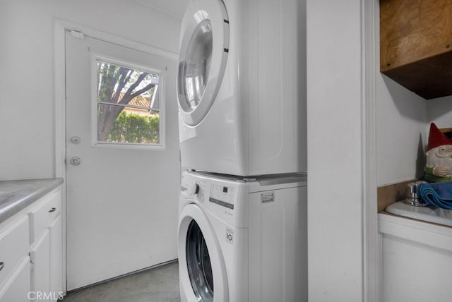22724 Califa St, Woodland Hills, CA 91367 - laundry area featuring stacked washer and clothes dryer and cabinet space