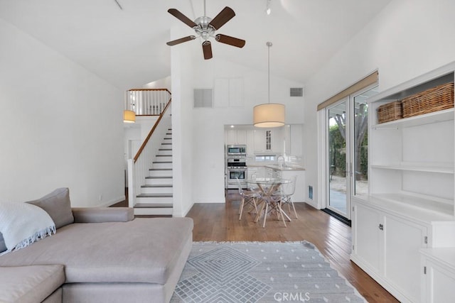 22724 Califa St, Woodland Hills, CA 91367 - living room with stairs, dark wood-type flooring, a ceiling fan, high vaulted ceiling, and baseboards