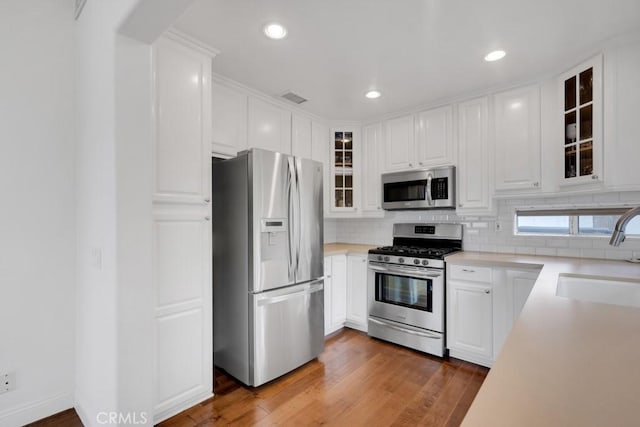 22724 Califa St, Woodland Hills, CA 91367 - kitchen featuring stainless steel appliances, a sink, white cabinets, tasteful backsplash, and recessed lighting