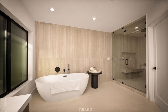 bathroom with a freestanding bath, recessed lighting, tile patterned floors, and a stall shower