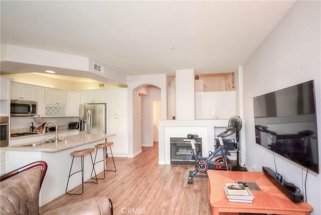 803 Maplewood, Irvine, CA 92618 - living room featuring light wood-type flooring, arched walkways, baseboards, visible vents, and recessed lighting