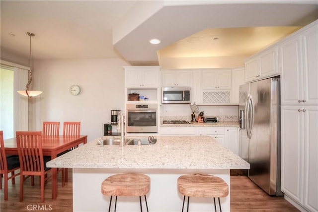 803 Maplewood, Irvine, CA 92618 - kitchen featuring wood finished floors, a sink, a breakfast bar area, stainless steel appliances, and white cabinets