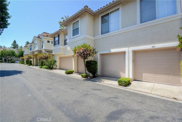 803 Maplewood, Irvine, CA 92618 - view of front of home featuring an attached garage, a tile roof, a residential view, and stucco siding